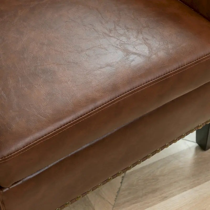 Gepolsterter Clubsessel aus Leder im Fassondesign mit Ziernägeln