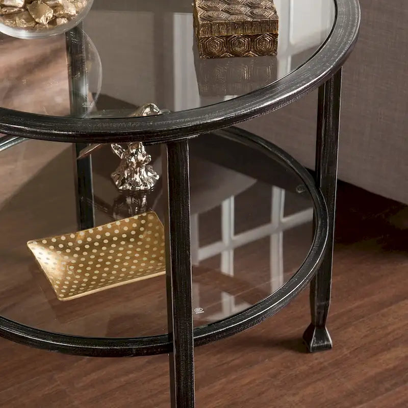 Runder Beistelltisch aus schwarzem Metall im Used-Look mit Glasplatte und Ablage